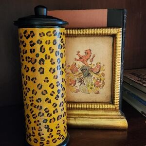 A decorative hand painted glass canister